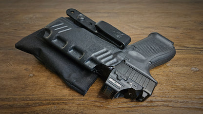 Black Stallster holster pillow attached to the back of a DeSantis holster, carrying a Glock 19