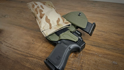 Desert MultiCam Stallster holster pillow attached to the back of a LLOD (Last Line of Defense) holster, carrying a Glock 19 and extra mag