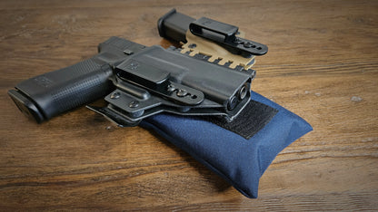 Navy blue Stallster holster pillow attached to the back of a T.Rex Arms sidecar holster, carrying a Glock 17 with extra mag