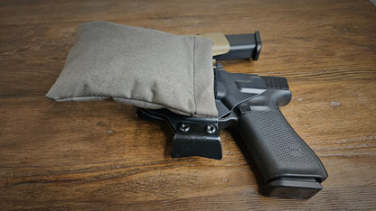 Tactical gray Stallster holster pillow attached to the back of a T.Rex Arms sidecar holster, carrying a Glock 17 with extra mag